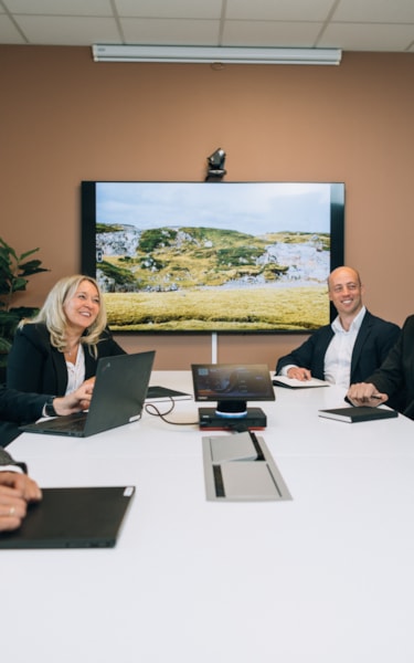 Ledergruppen samlet rundt avlangt hvitt bord på møterom